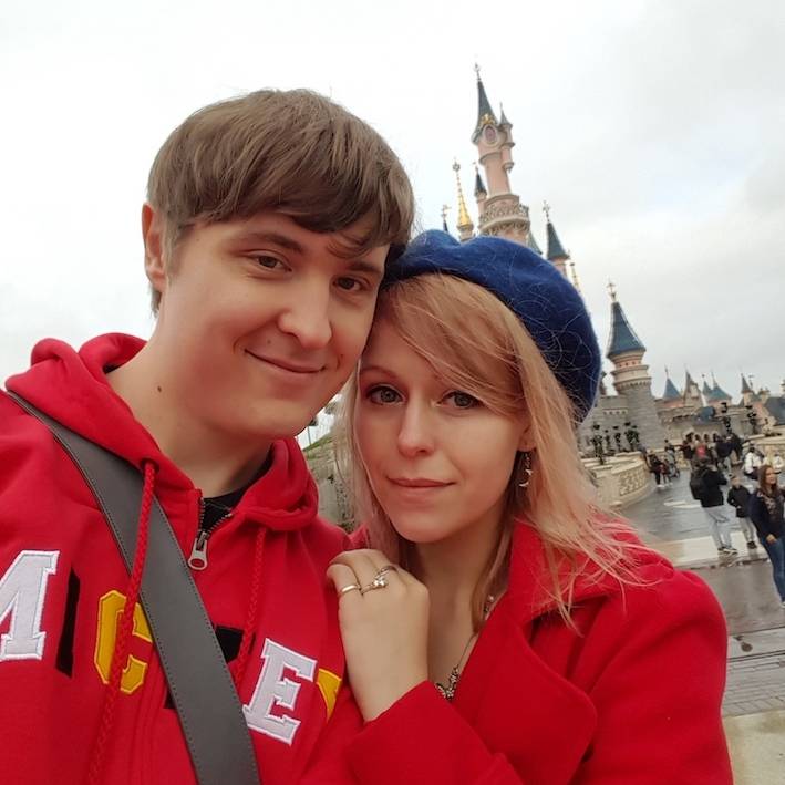 Image of James and his partner in front of Disneyland Castle